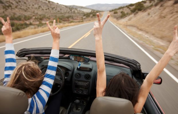 Summertime Hands up, while driving a convertible.