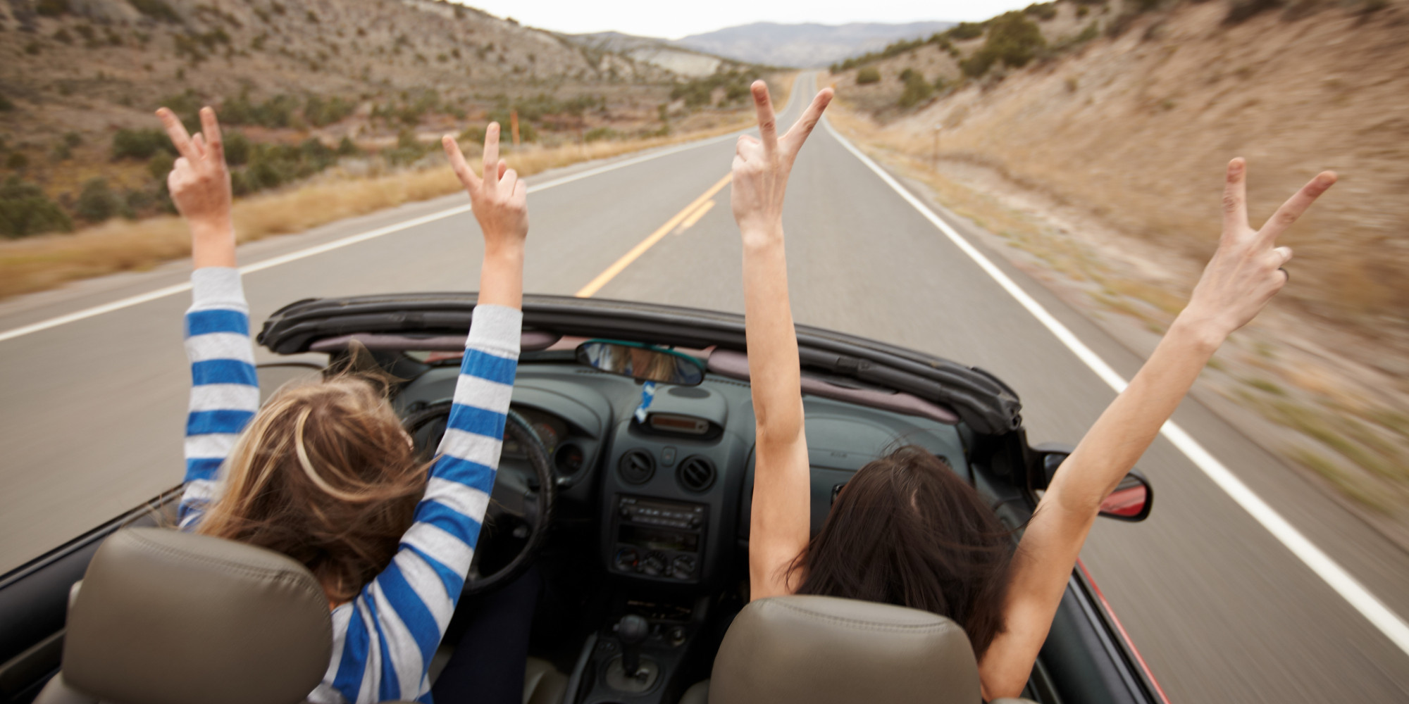 Summertime Hands up, while driving a convertible.